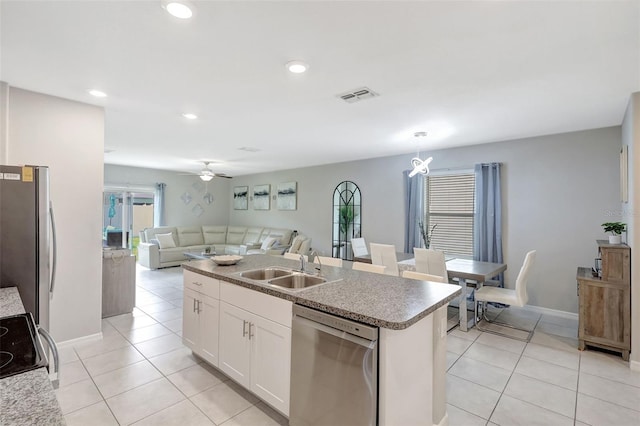 kitchen with visible vents, appliances with stainless steel finishes, light tile patterned flooring, a sink, and open floor plan