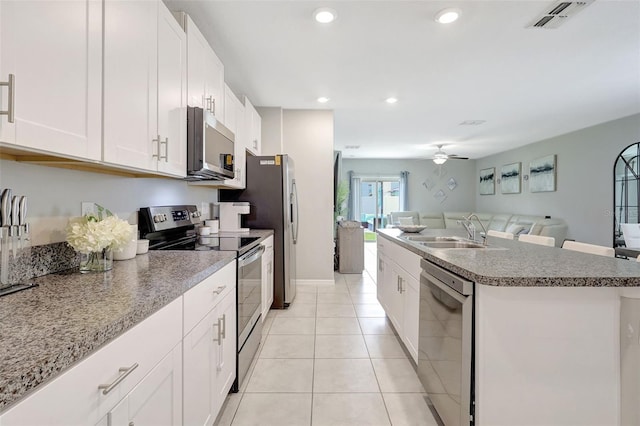 kitchen with ceiling fan, visible vents, a sink, stainless steel appliances, and open floor plan