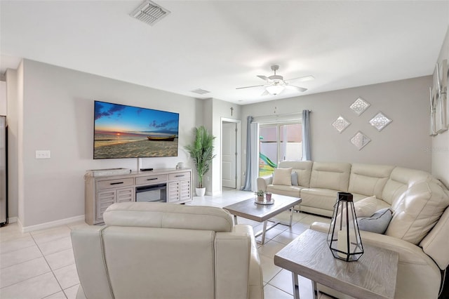 living area featuring baseboards, light tile patterned flooring, ceiling fan, and visible vents