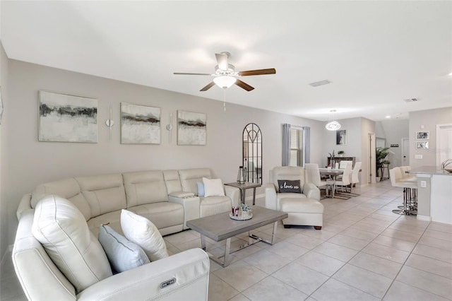 living room featuring light tile patterned floors, visible vents, and a ceiling fan