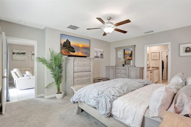 bedroom featuring light colored carpet, ensuite bathroom, baseboards, and visible vents