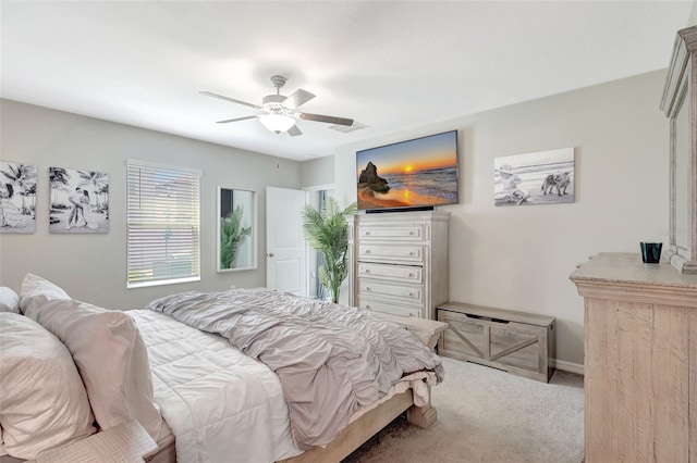 carpeted bedroom with visible vents, baseboards, and a ceiling fan