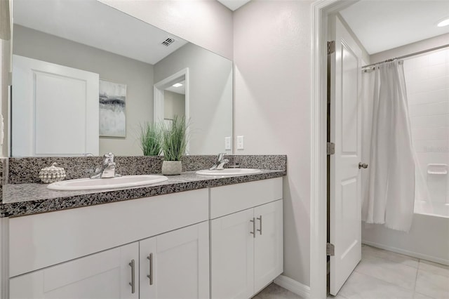 full bath with shower / bath combo, double vanity, a sink, and visible vents