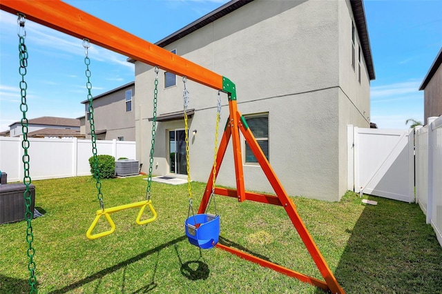 view of jungle gym with a yard, a fenced backyard, and a gate