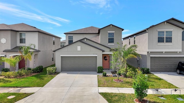 traditional-style house featuring a front yard, an attached garage, driveway, and stucco siding