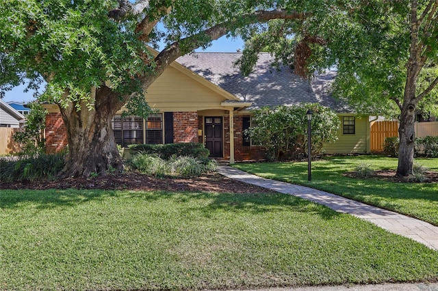 2809 Kimberly Ln, Tampa, FL 33618 - view of front of home with brick siding, a front lawn, fence, and a shingled roof