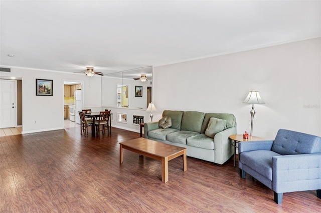 living room featuring baseboards, visible vents, wood finished floors, and a ceiling fan