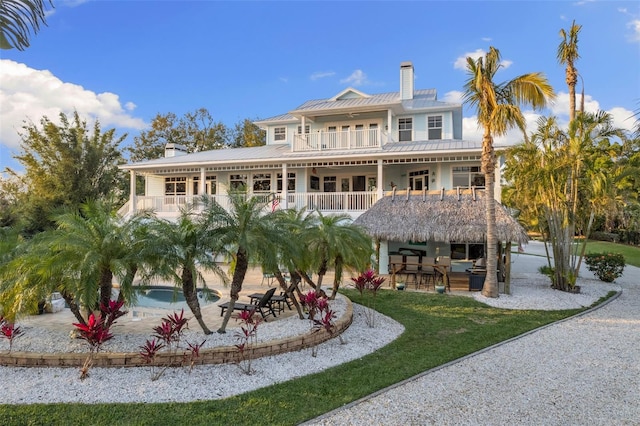 450 Bayshore Dr, Terra Ceia, FL 34250 - rear view of house with a chimney, a balcony, outdoor dry bar, and a patio