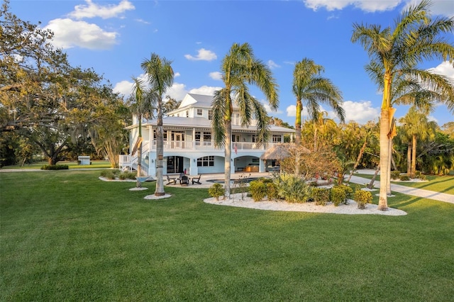 450 Bayshore Dr, Terra Ceia, FL 34250 - rear view of house with a balcony, a lawn, stairs, and a patio