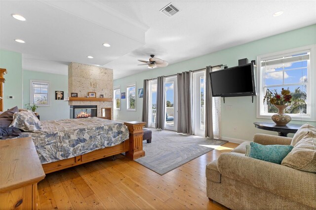 450 Bayshore Dr, Terra Ceia, FL 34250 - bedroom with a large fireplace, visible vents, access to outside, multiple windows, and light wood-type flooring