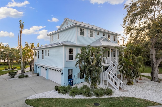 450 Bayshore Dr, Terra Ceia, FL 34250 - exterior space featuring a porch, a garage, concrete driveway, and stairway