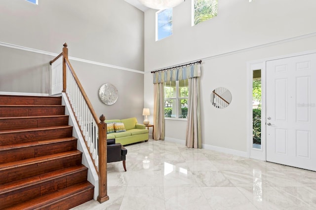 foyer entrance featuring marble finish floor, stairway, and a wealth of natural light