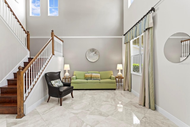 living area featuring baseboards, marble finish floor, a high ceiling, and stairway
