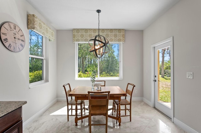 dining area with a notable chandelier and baseboards