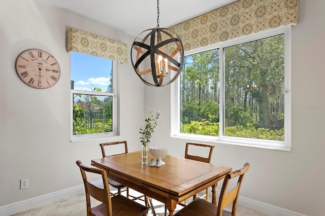 dining space featuring baseboards and a chandelier