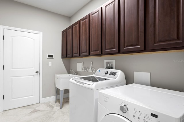 washroom featuring marble finish floor, cabinet space, baseboards, and separate washer and dryer