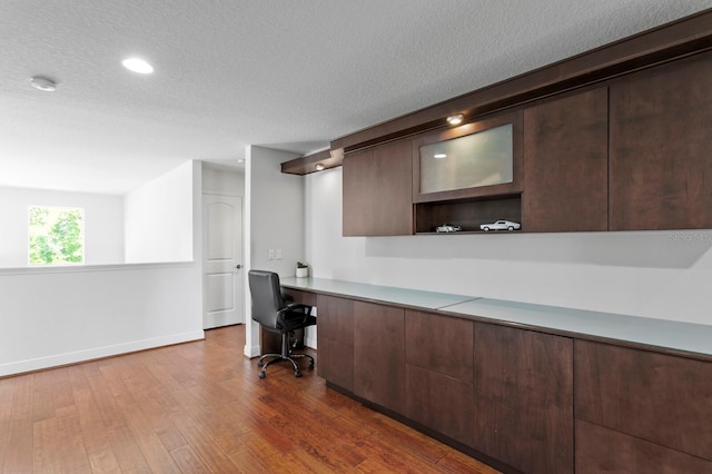 office area featuring dark wood finished floors, baseboards, and a textured ceiling