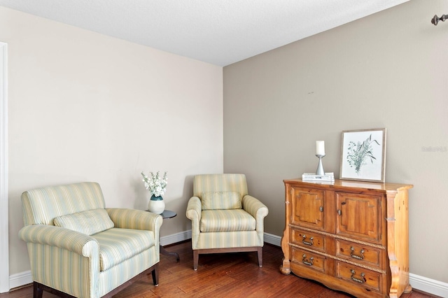 sitting room with baseboard heating, baseboards, and wood finished floors