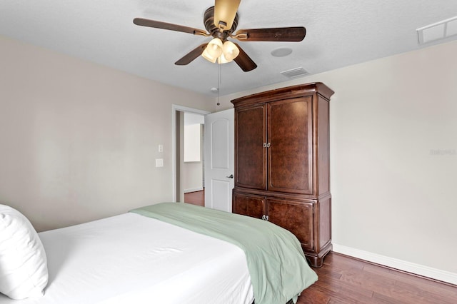bedroom featuring dark wood-type flooring, baseboards, visible vents, and a ceiling fan