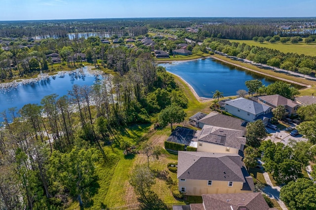 birds eye view of property featuring a water view and a view of trees