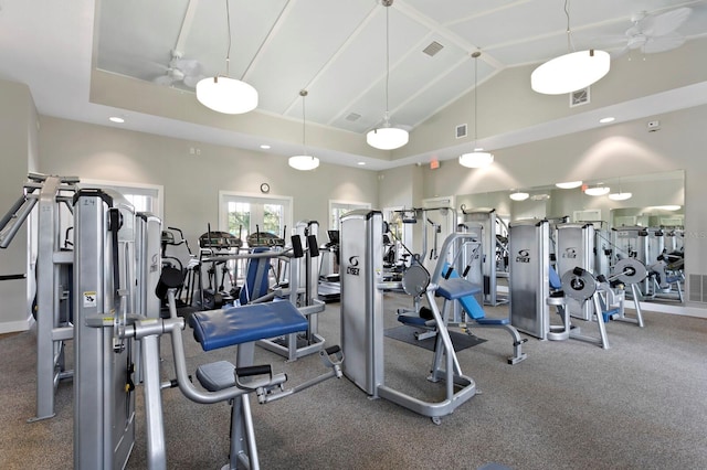 exercise room featuring high vaulted ceiling and visible vents