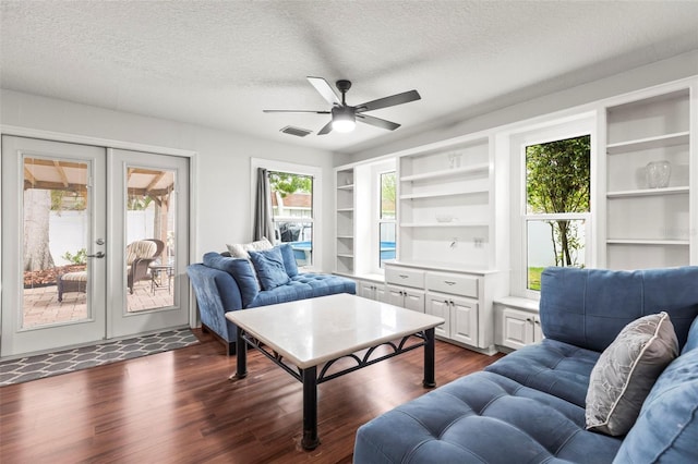 living room featuring a textured ceiling, a ceiling fan, visible vents, dark wood-style flooring, and french doors