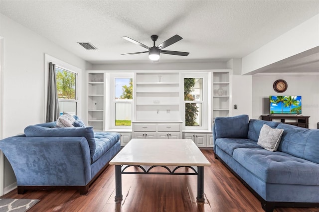 living area with visible vents, ceiling fan, a textured ceiling, and dark wood-style floors