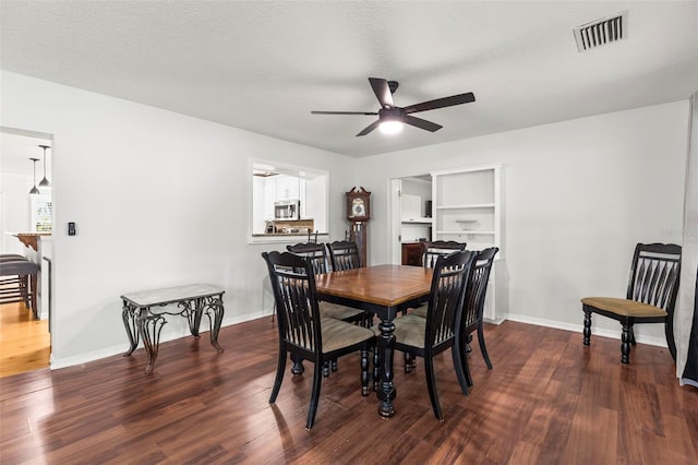 dining room with visible vents, baseboards, a ceiling fan, and wood finished floors
