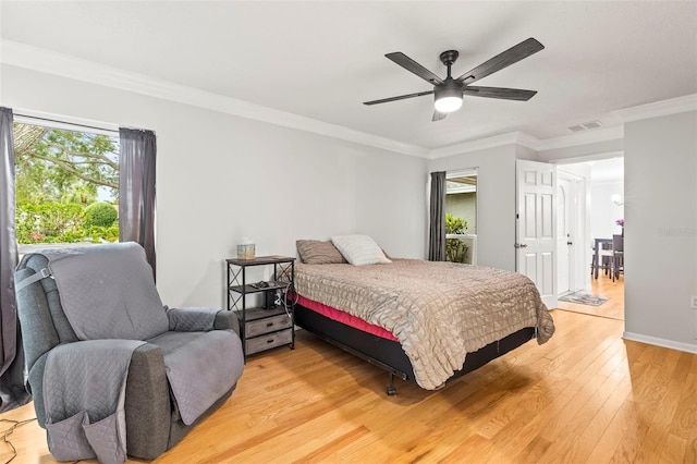 bedroom with light wood-type flooring, ceiling fan, crown molding, and visible vents
