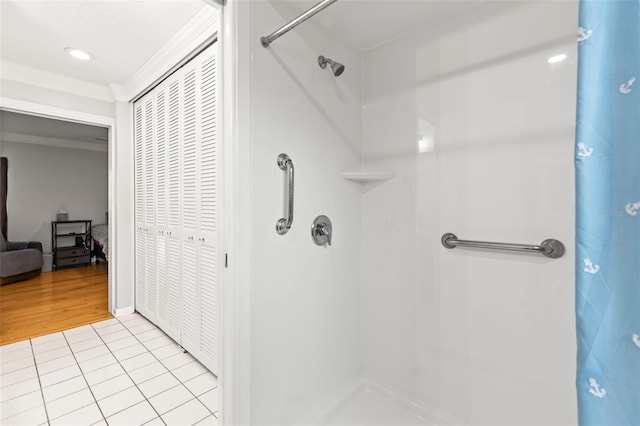 bathroom featuring crown molding, tile patterned flooring, and walk in shower