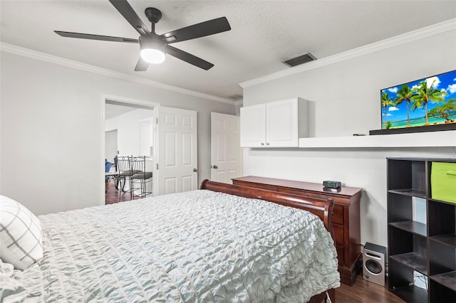 bedroom featuring ceiling fan, a textured ceiling, ornamental molding, visible vents, and dark wood-style flooring