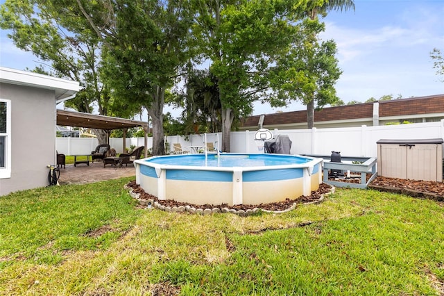view of swimming pool with a fenced backyard, a patio area, and a lawn