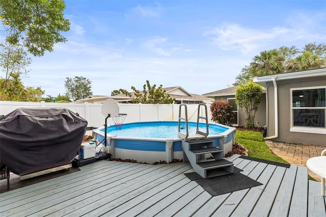 view of swimming pool featuring a fenced in pool, a deck, a grill, and fence