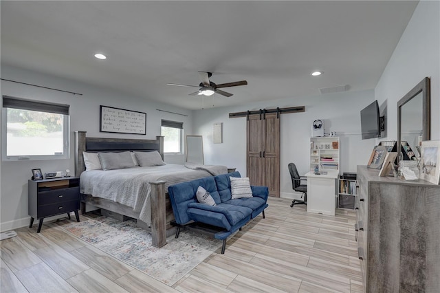 bedroom featuring baseboards, visible vents, a barn door, and recessed lighting