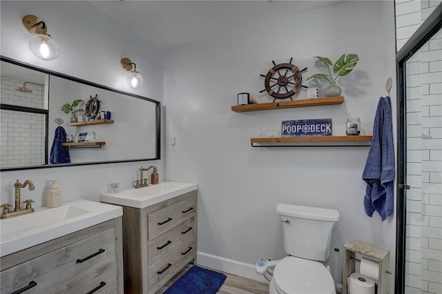 full bathroom featuring a sink, toilet, two vanities, and wood finished floors