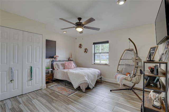 bedroom featuring baseboards, a closet, light wood-style floors, and ceiling fan