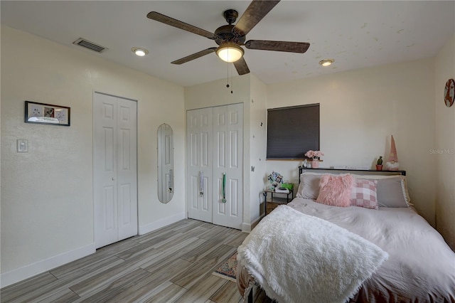 bedroom with baseboards, visible vents, wood finished floors, and a ceiling fan