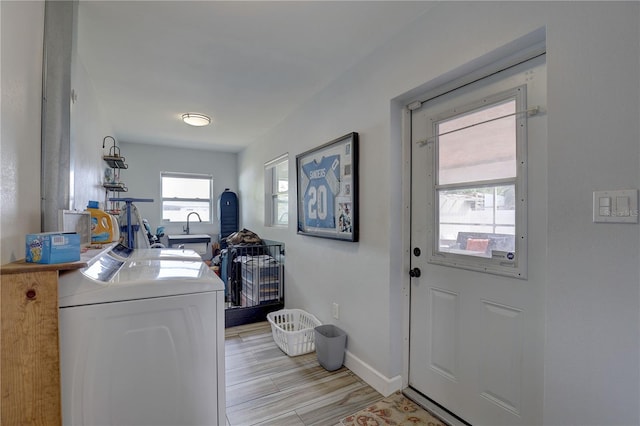 laundry area featuring baseboards, washer and dryer, laundry area, and a sink