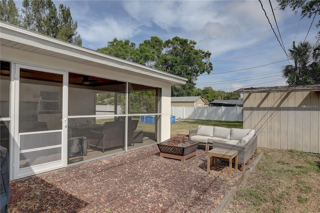 view of yard with an outbuilding, an outdoor living space with a fire pit, a sunroom, and fence
