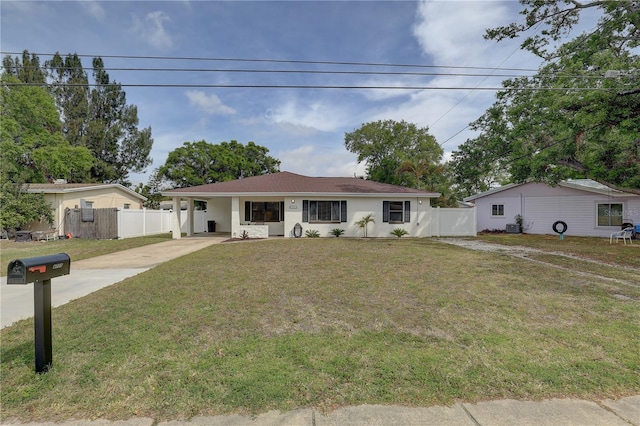 ranch-style home featuring an attached carport, fence, concrete driveway, and a front yard