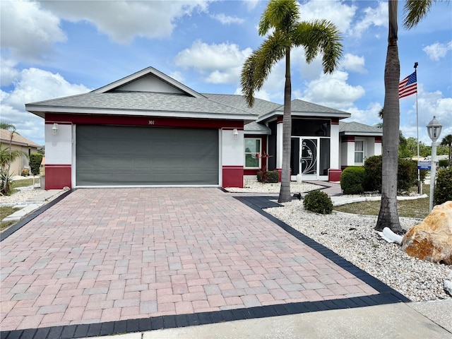 301 Caloosa Palms Ct, Sun City Center, FL 33573 - ranch-style house with decorative driveway, an attached garage, a shingled roof, and stucco siding