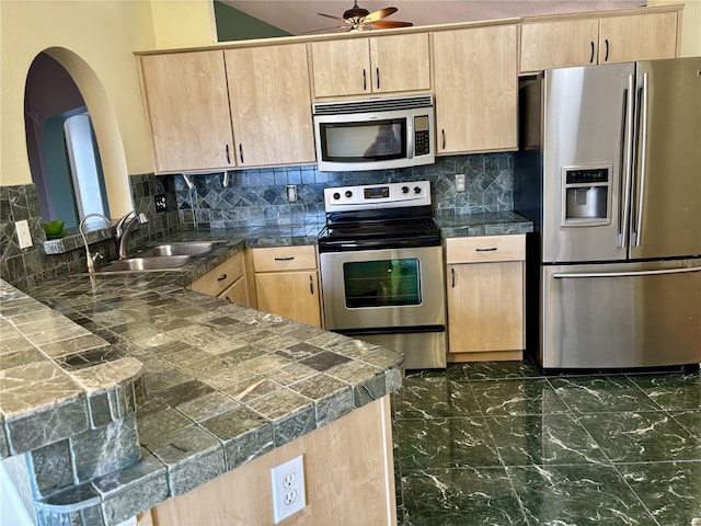 301 Caloosa Palms Ct, Sun City Center, FL 33573 - kitchen with appliances with stainless steel finishes, light brown cabinets, arched walkways, a peninsula, and ceiling fan