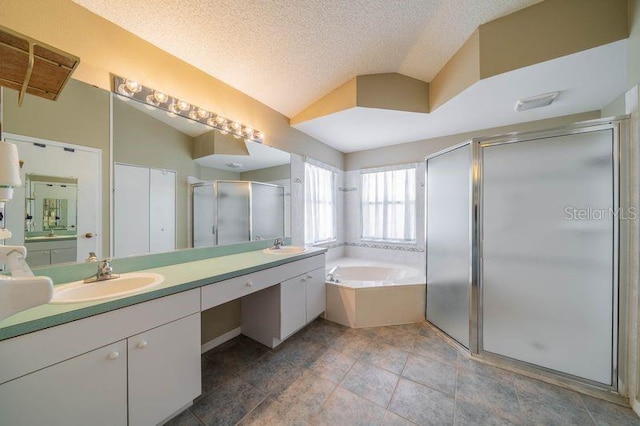 301 Caloosa Palms Ct, Sun City Center, FL 33573 - full bathroom with double vanity, a shower stall, a garden tub, lofted ceiling, and a textured ceiling