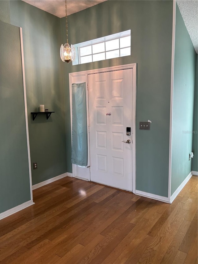 301 Caloosa Palms Ct, Sun City Center, FL 33573 - entryway with a chandelier, wood finished floors, and a textured ceiling