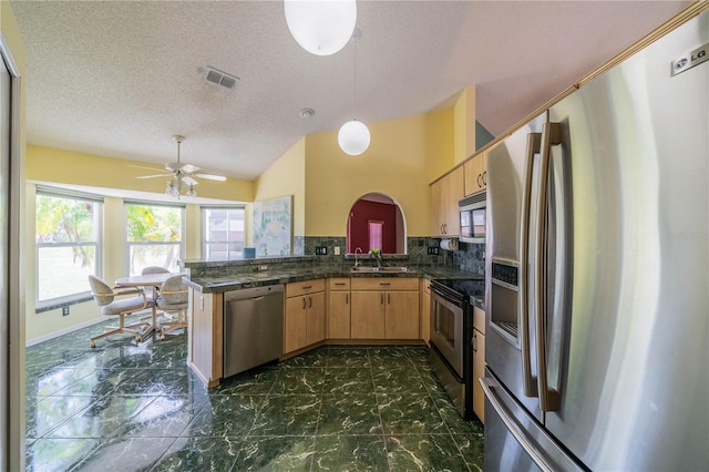301 Caloosa Palms Ct, Sun City Center, FL 33573 - kitchen featuring appliances with stainless steel finishes, a peninsula, dark countertops, dark marble finish floors, and ceiling fan