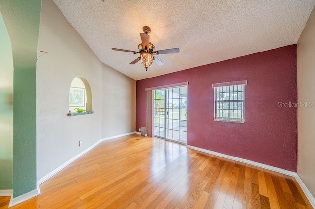 301 Caloosa Palms Ct, Sun City Center, FL 33573 - empty room featuring a textured ceiling, light wood-type flooring, a ceiling fan, vaulted ceiling, and radiator
