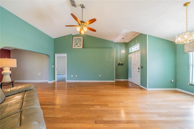 301 Caloosa Palms Ct, Sun City Center, FL 33573 - unfurnished living room featuring ceiling fan, a chandelier, light wood-type flooring, high vaulted ceiling, and arched walkways