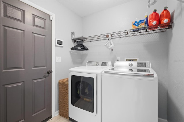 clothes washing area featuring baseboards, independent washer and dryer, and laundry area
