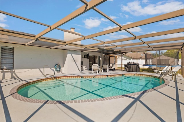 view of pool featuring a patio area, a trampoline, fence, glass enclosure, and a fenced in pool