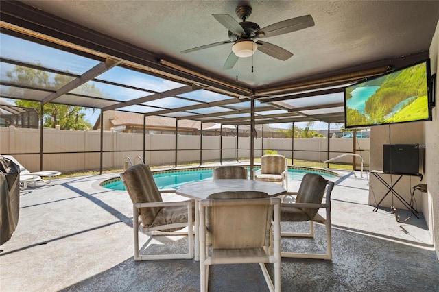 view of patio / terrace featuring ceiling fan, a fenced in pool, fence, and glass enclosure
